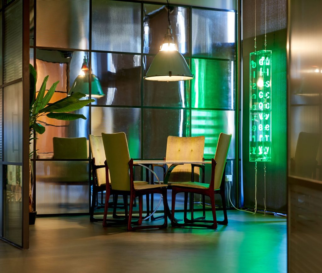 Breakout area in BGF's Birmingham office, with green light up sign reading 'Discovery'