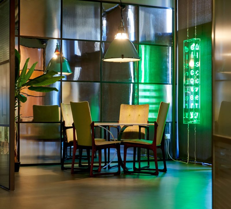 Breakout area in BGF's Birmingham office, with green light up sign reading 'Discovery'