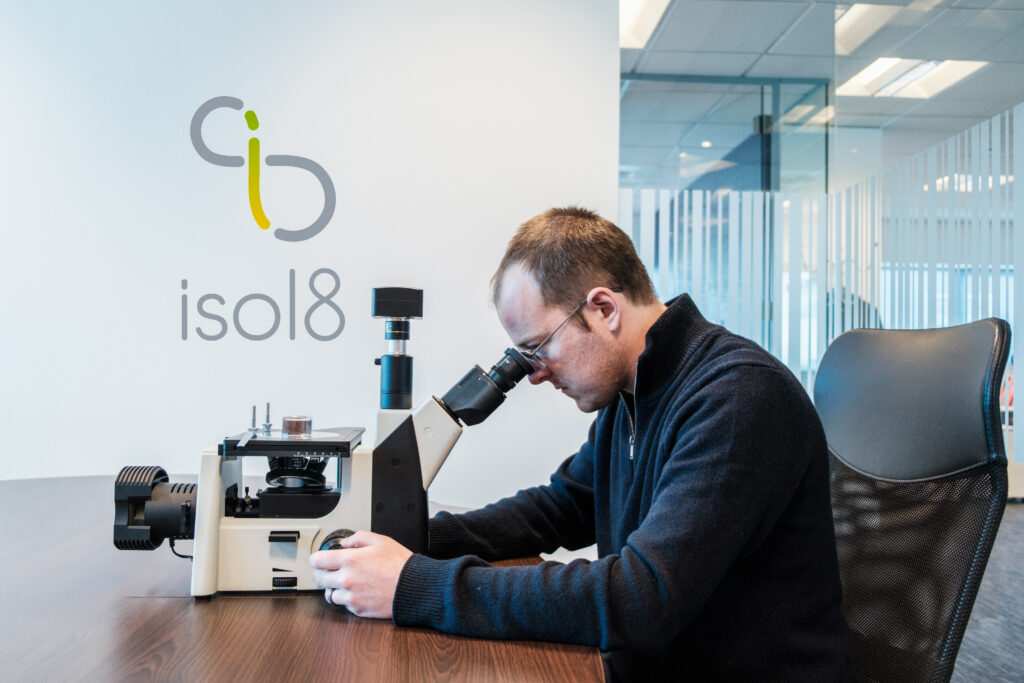 isol8 team member working at a microscope at the company's HQ